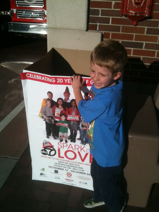 T drops some toys in the Spark of Love donation box outside of the fire station on 2nd Street in Long Beach (CA).