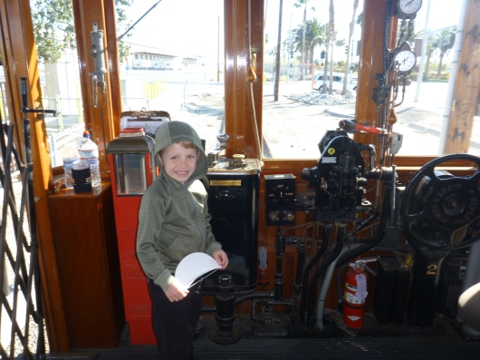 T posing in front of the driving equipment of the replica PE Red Car in San Pedro, CA.